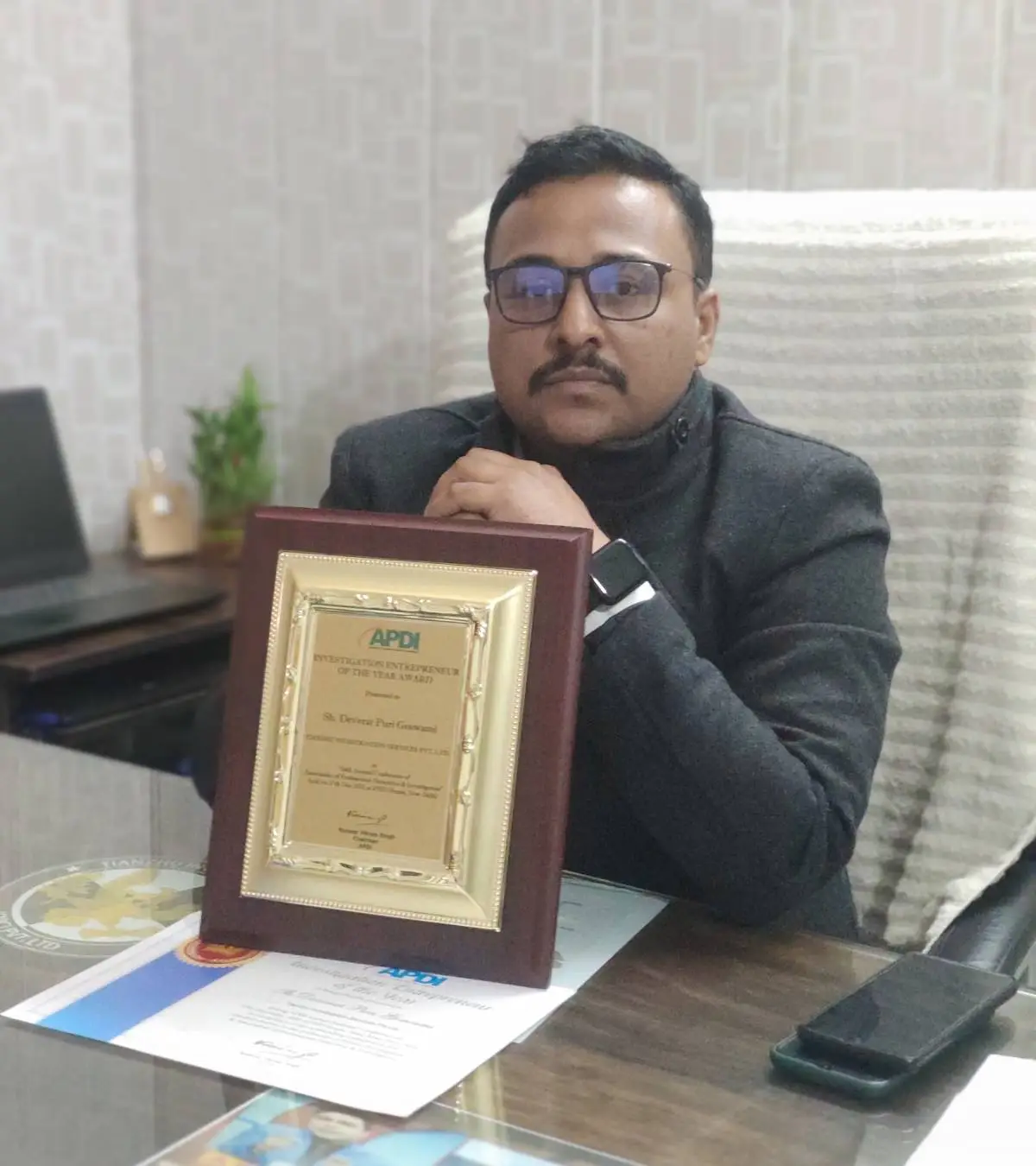 Bhopal Detective Services agency owner with award at office.